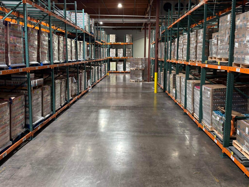 warehouse aisle with palletized inventory stored on industrial racks